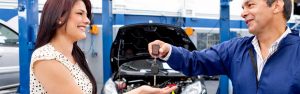 Woman getting her back car from the mechanic after a checkup