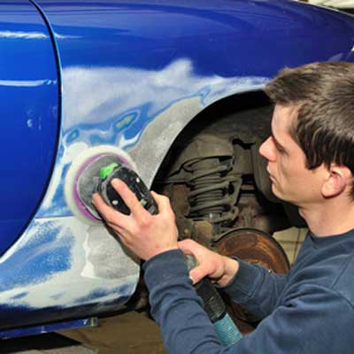 mechanic buffing fiberglass used to repair rust damage