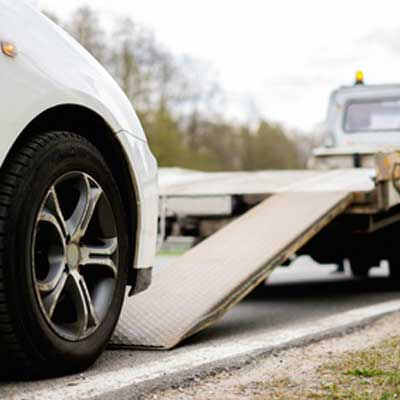 loading broken car on tow truck