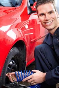 mechanic smiling while filling tires with air
